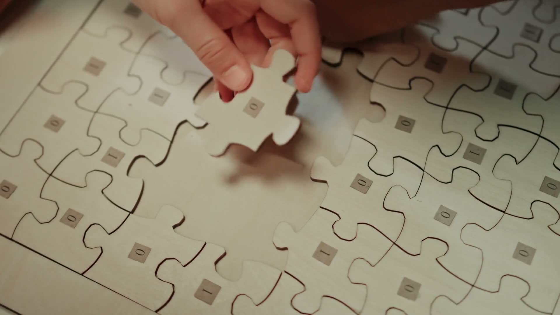 A hand placing a jigsaw piece into the puzzle